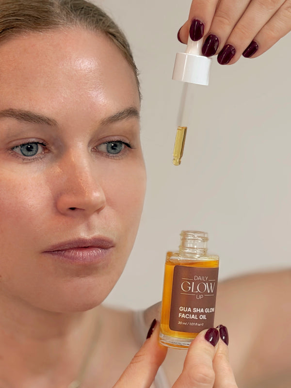 Frau trägt das Daily Glow Up Gua Sha Glow Facial Oil für die Gesichtspflege auf.