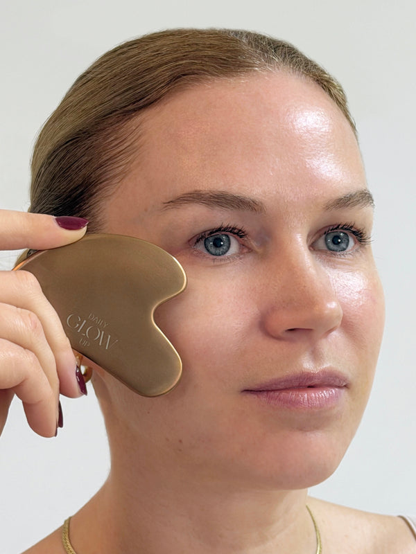 Anwendung des Daily Glow Up Gua Sha Tools bei einer sanften Gesichtsmassage.