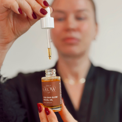 Frau trägt das Daily Glow Up Facial Oil als Vorbereitung für die Gua Sha Massage auf.