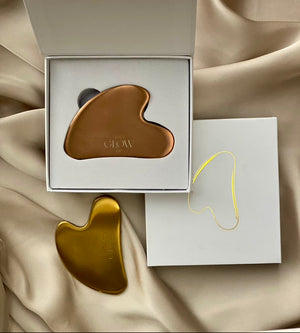 Daily Glow Up Gua Sha Steine in Gold und Bronze mit hochwertiger Verpackung.