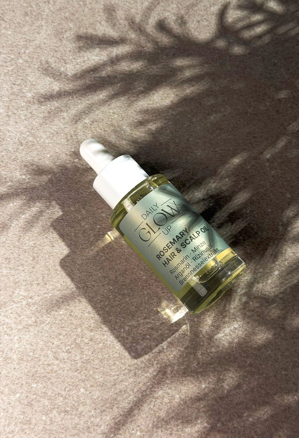 Daily Glow Up Rosemary Hair & Scalp Strengthening Oil in einer ruhigen Badezimmer-Pflegeszene.