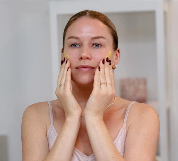 Frau trägt das Daily Glow Up Vitamin C Serum bei der Gesichtspflege auf.